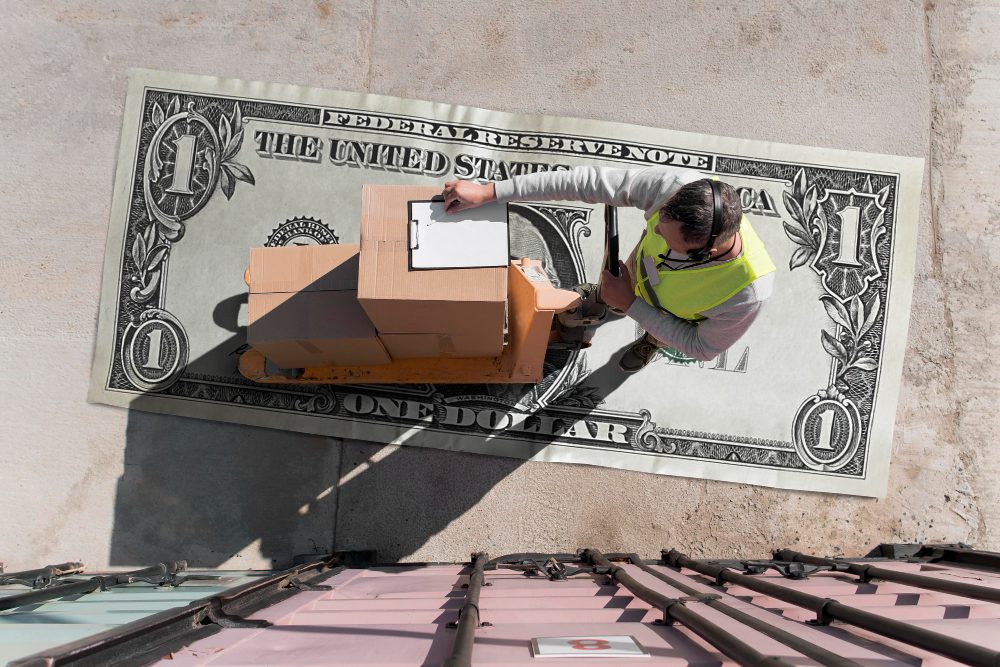 Aerial view of worker scanning box on money bill with iDrive Logistics logo and slogan